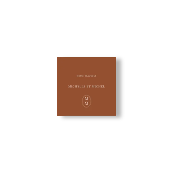 Carte de remerciement fond chocolat lait, prénoms et monogramme crème centrés. Élégante, simple et graphique.