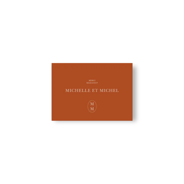 Carte de remerciement caramel avec “Merci beaucoup”, prénoms centrés et monogramme clair en bas.