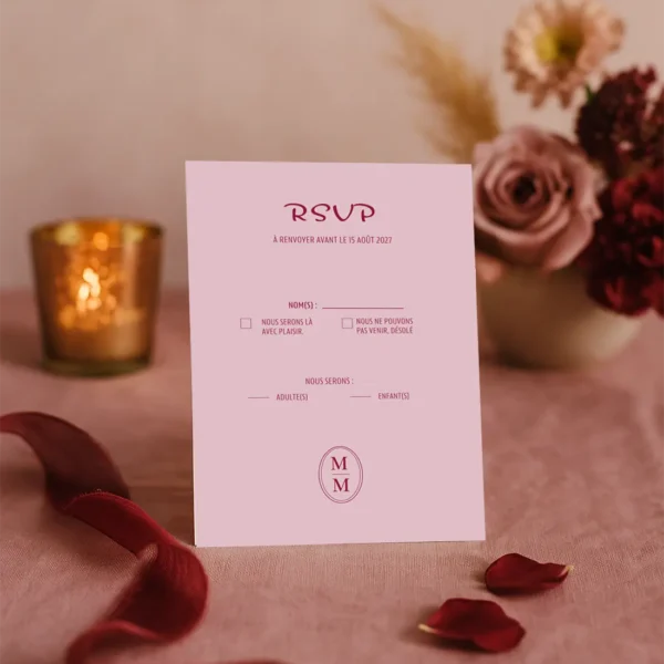 Carte RSVP mariage rose poudré, texte rouge bordeaux. Mise en page claire et romantique.